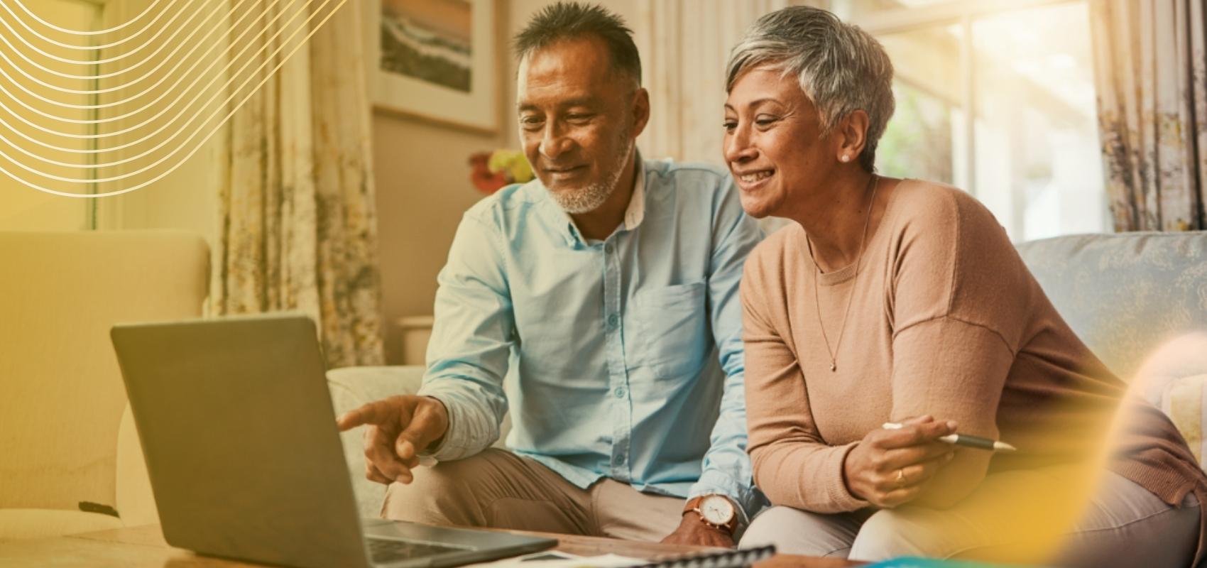 An older couple reviewing family memories together on a laptop